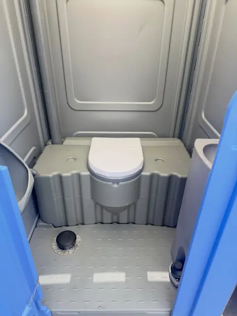 Roomy porta potty interior with a ground-level floor